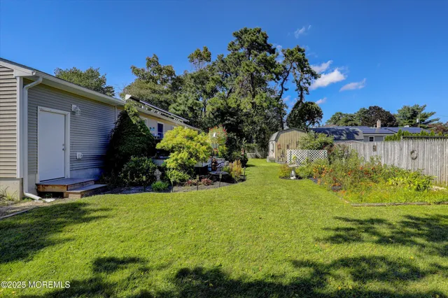 a view of backyard with barbeque grill potted plants and large tree