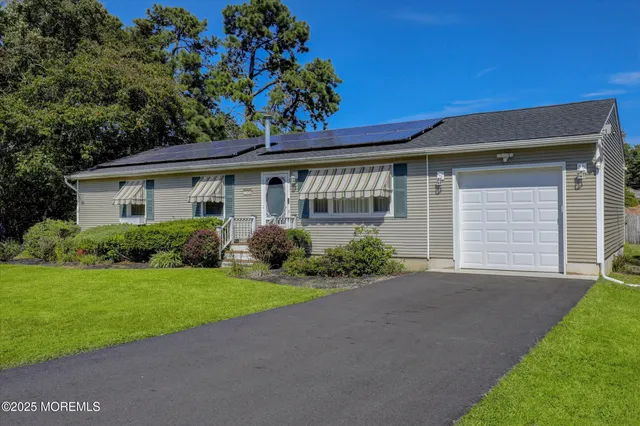 a front view of a house with a garden and yard