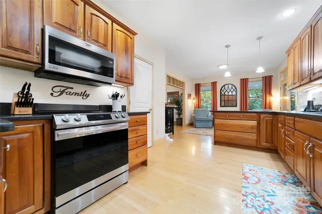 a kitchen with stainless steel appliances a stove a microwave and cabinets