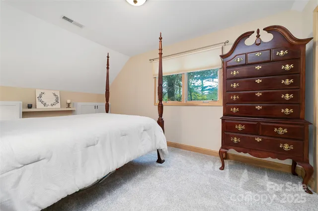 a bedroom with a bed a dresser and a window