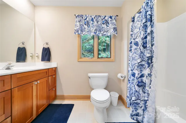 a bathroom with a granite countertop sink toilet and a large mirror