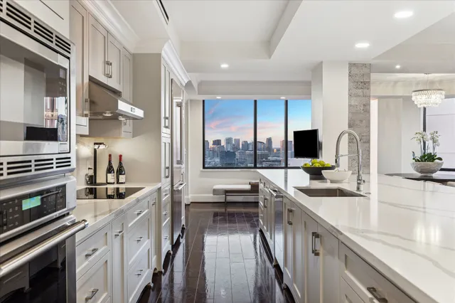 a large kitchen with granite countertop lots of counter space and view of living room