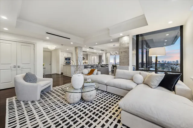 a living room with furniture wooden floor and a large window