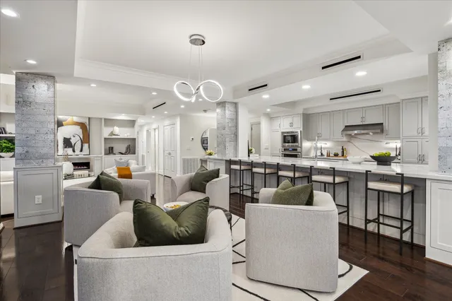a living room with furniture kitchen and a chandelier