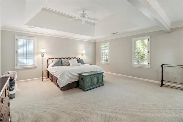 a bedroom with a bed lamps and windows