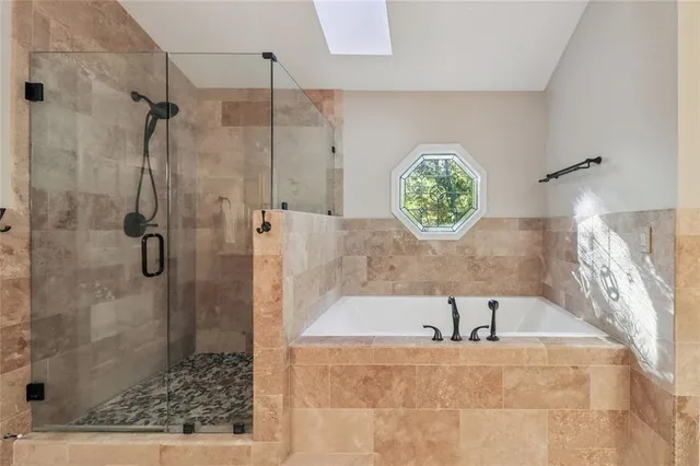 a bathroom with a tub shower and window