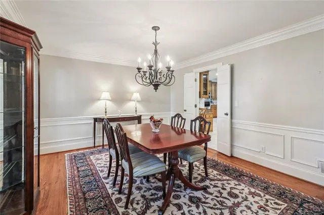 a dining room with furniture a chandelier and wooden floor