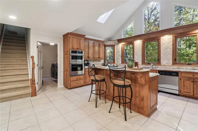 a dining hall with stainless steel appliances a dining table and chairs