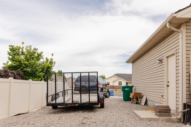 972 West 2840th Street South Logan, UT 84321 - Photo 46 of 46 Gravel driveway leading to a side entry door and a vinyl fence