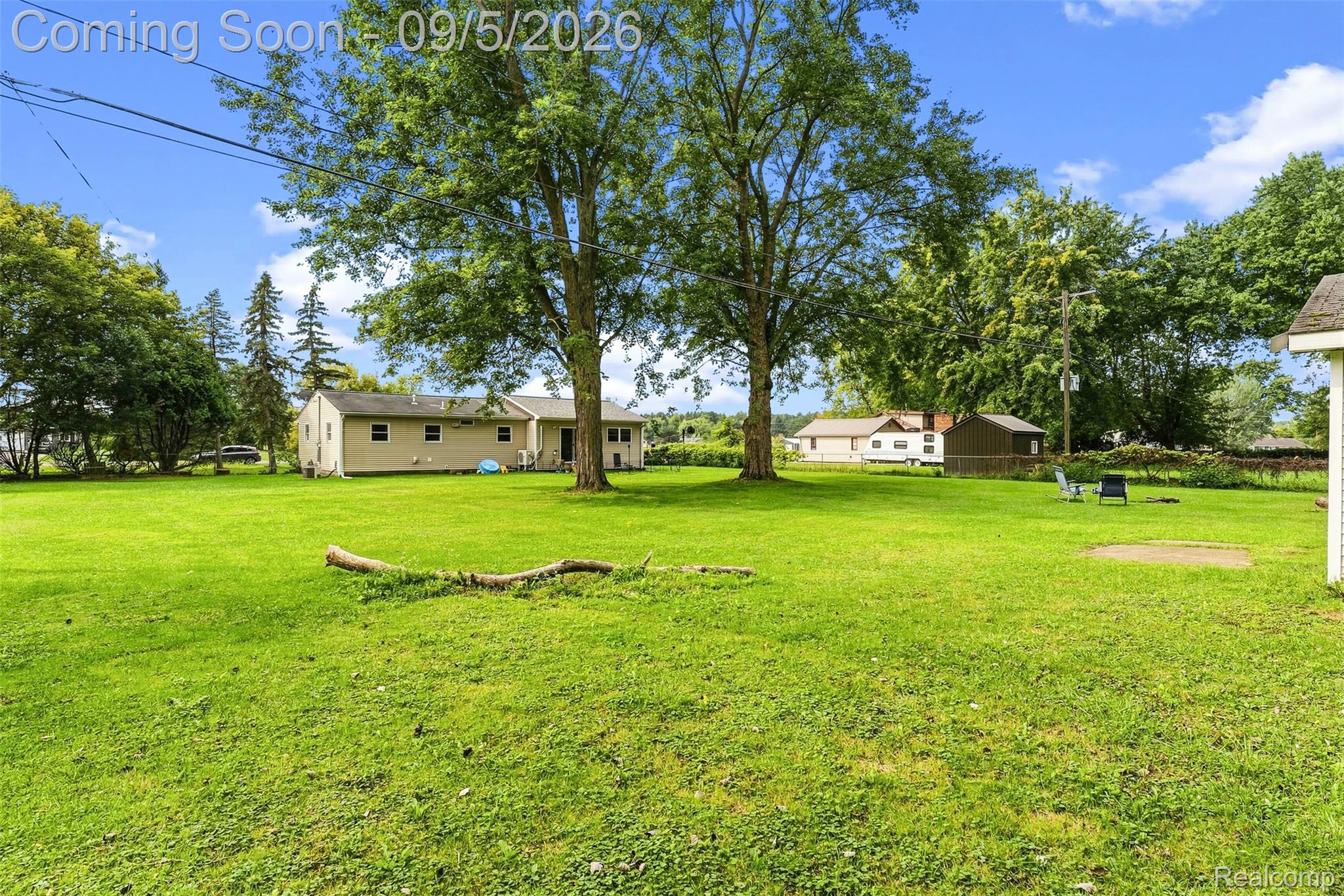 2071 East Dodge Road Clio, MI 48420 - Photo 38 of 38 Expansive green lawn with mature trees and a single-story residence featuring light-colored siding