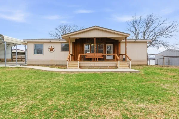a view of a house with a yard patio and fire pit