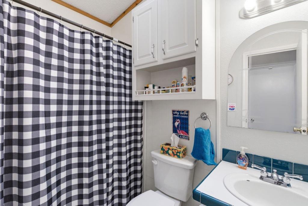 1919 Eastside Lake Road Graham, TX 76450 - Photo 16 of 24 a bathroom with a sink toilet and a mirror
