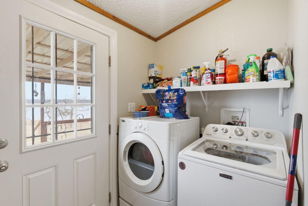 1919 Eastside Lake Road Graham, TX 76450 - Photo 17 of 24 a utility room with dryer washer and a fridge