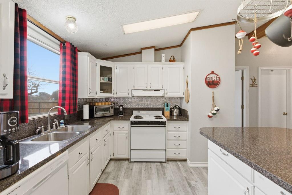 1919 Eastside Lake Road Graham, TX 76450 - Photo 8 of 24 a kitchen with granite countertop a sink stainless steel appliances and cabinets
