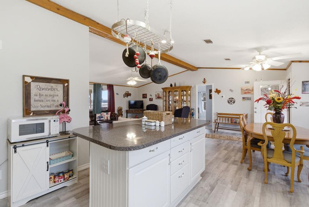 1919 Eastside Lake Road Graham, TX 76450 - Photo 10 of 24 a kitchen with stainless steel appliances granite countertop a sink dishwasher and white cabinets with wooden floor