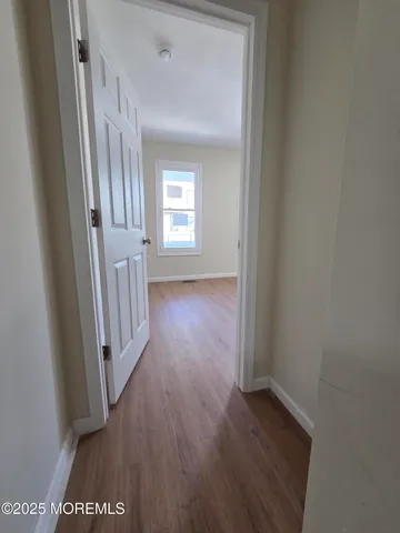 an empty room with wooden floor and closet