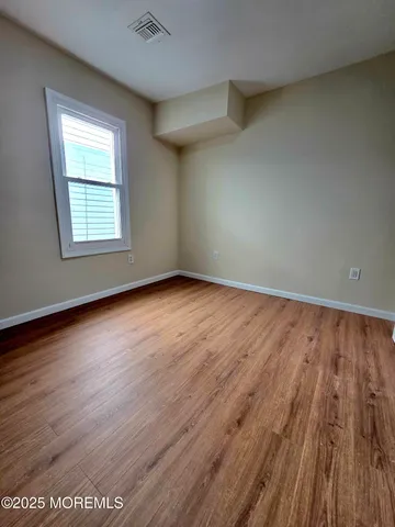 a view of a hallway with wooden floor and stairs