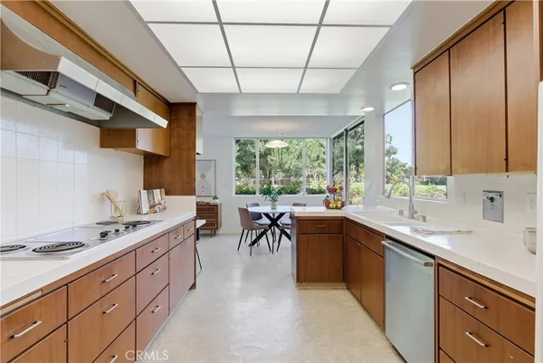 a kitchen with a sink table and chairs
