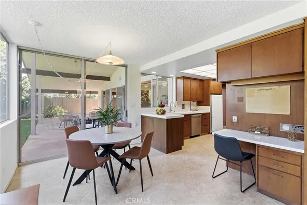 a dining room with furniture and potted plants