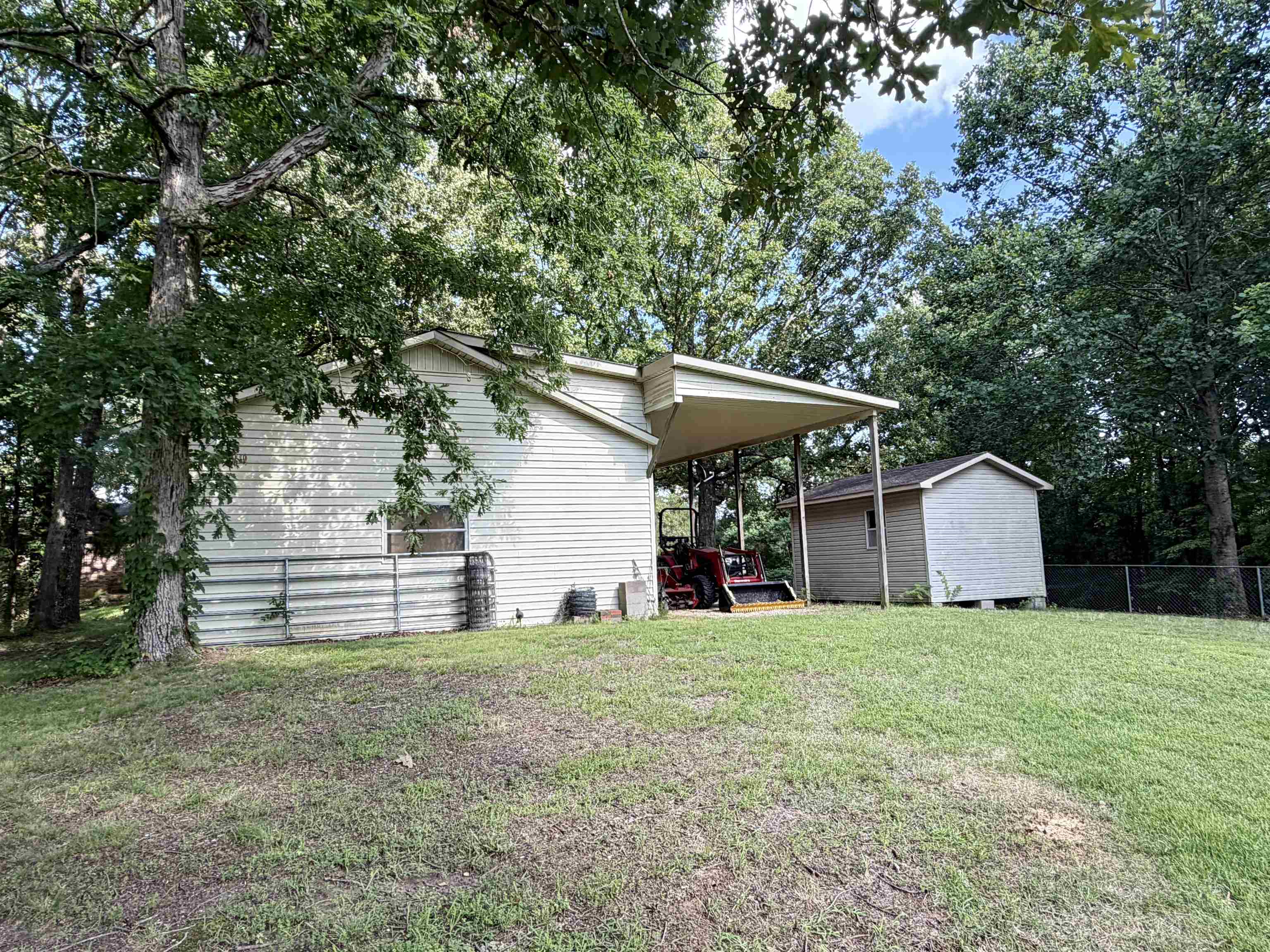 373 Clarence Barham Road Bethel Springs, TN 38315 - Photo 25 of 28 Exterior featuring tan siding, a covered carport, and a detached storage shed