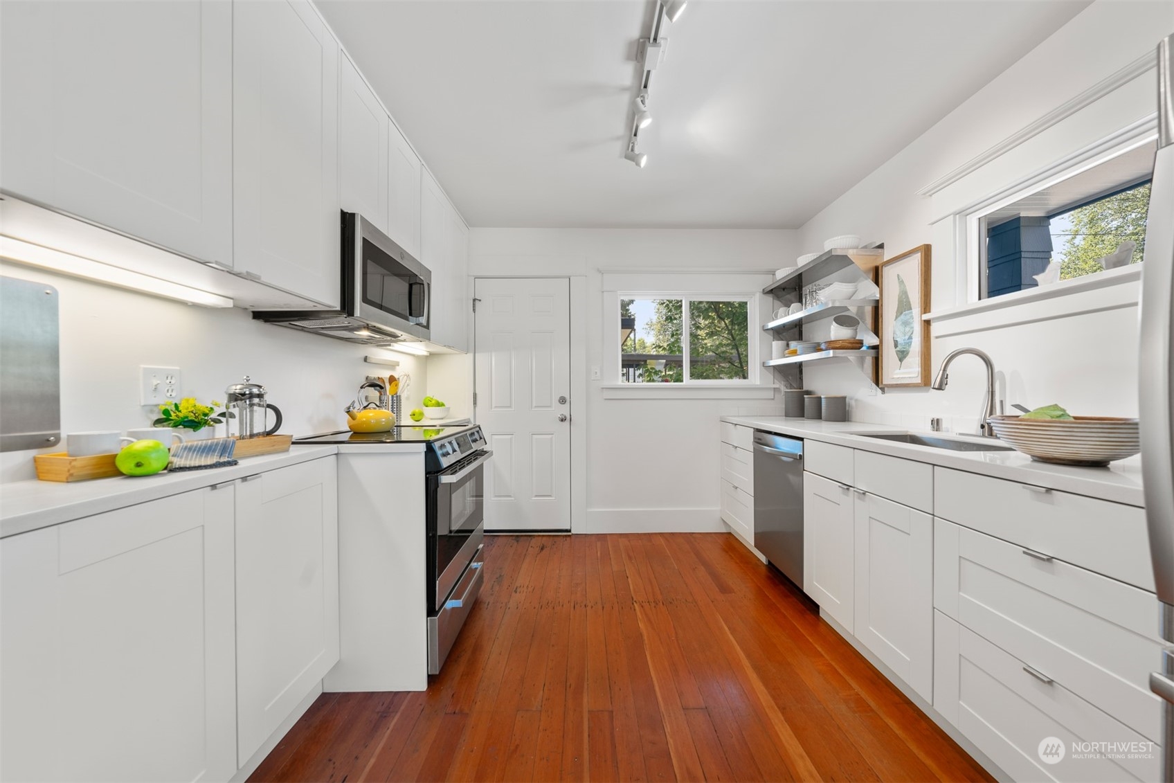 2506 Walnut Avenue Southwest Seattle, WA 98116 - Photo 7 of 29 a kitchen with stainless steel appliances a white cabinets and wooden floor