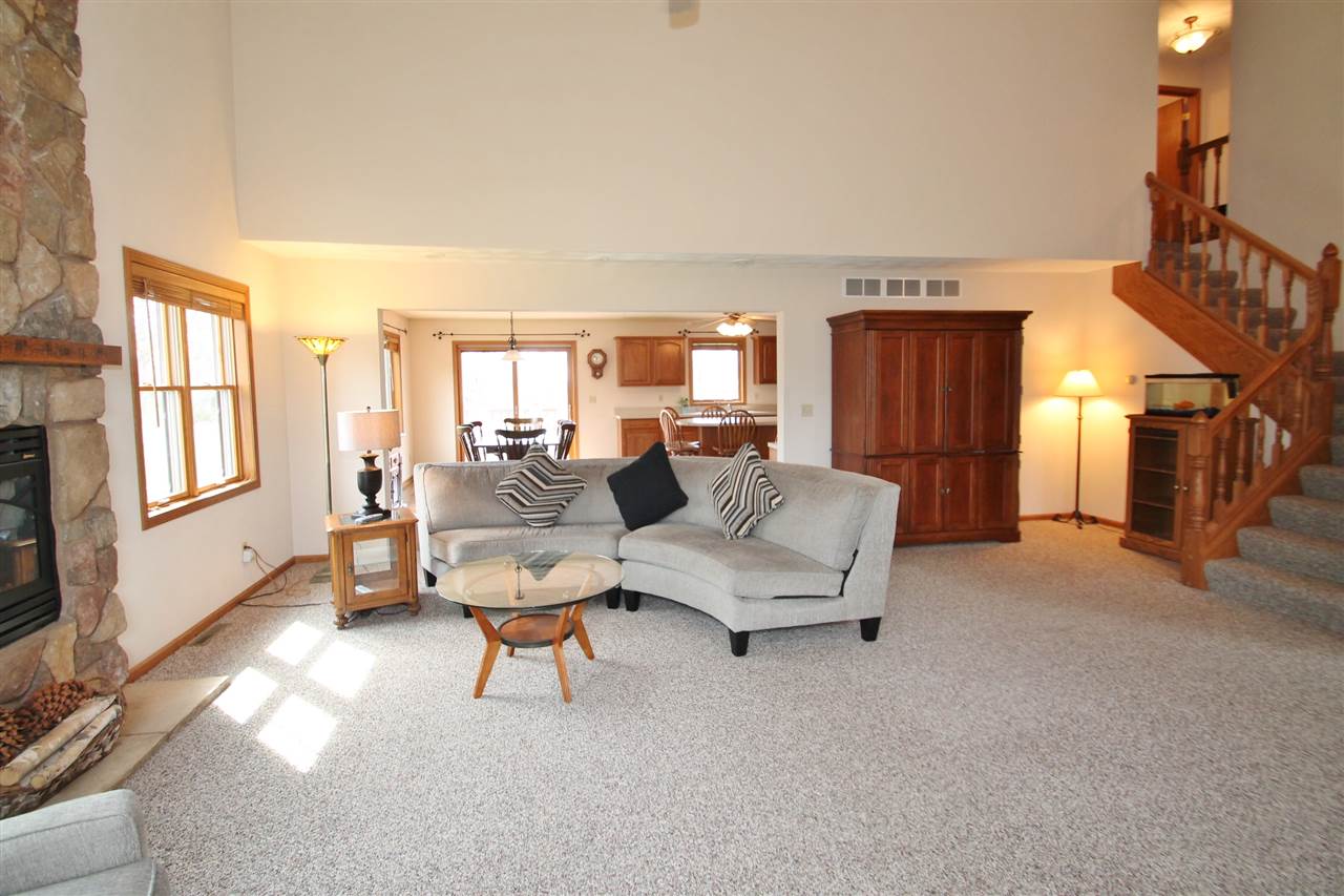 4461 Ridgeview Lane Byron, IL 61010 - Photo 5 of 25 a living room with furniture and a flat screen tv with kitchen view
