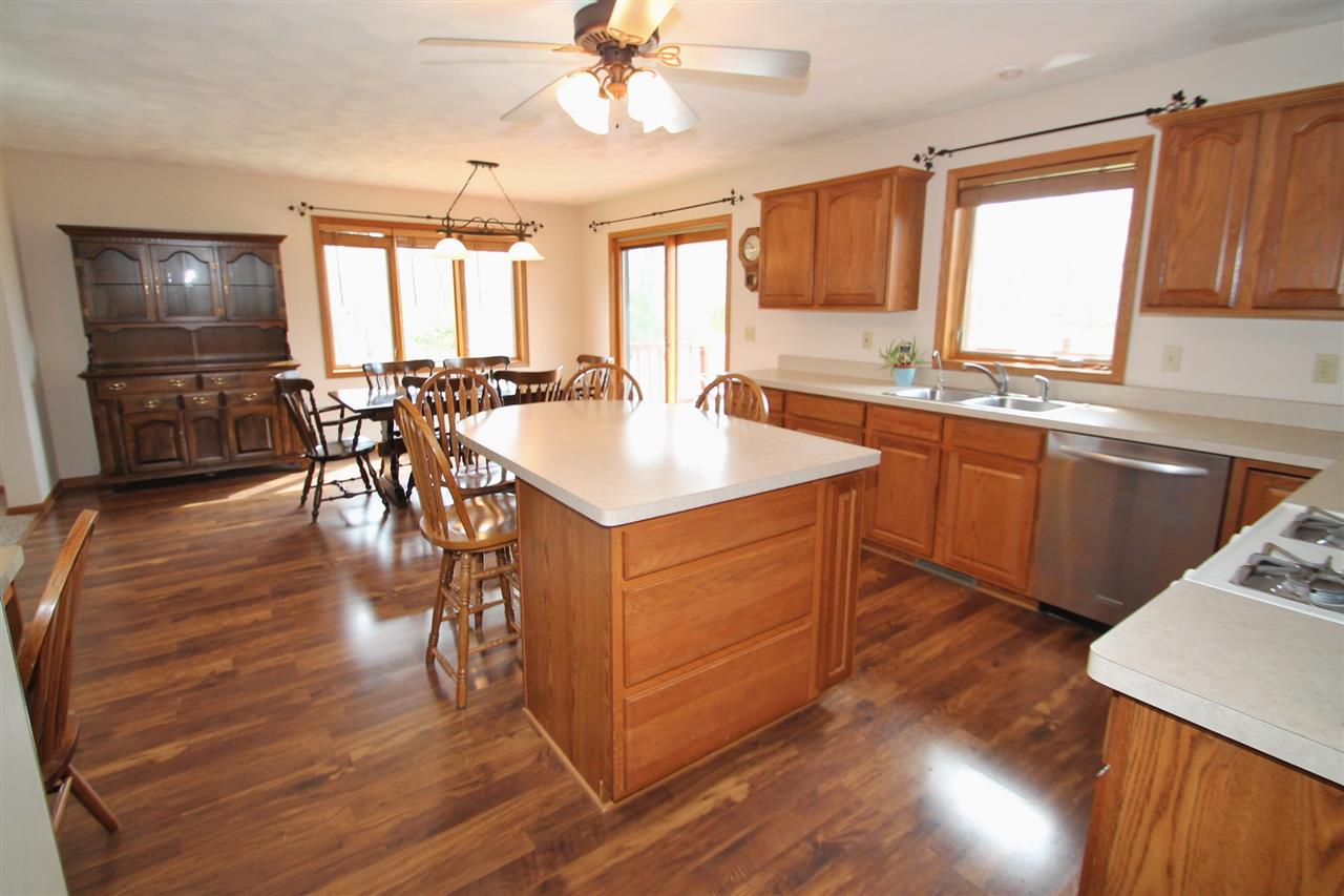 4461 Ridgeview Lane Byron, IL 61010 - Photo 9 of 25 a kitchen with stainless steel appliances granite countertop wooden floors and white cabinets