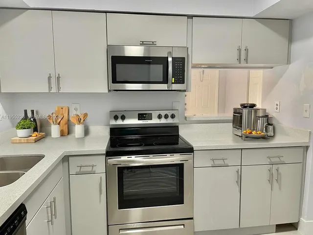 a kitchen with white cabinets stainless steel appliances and sink