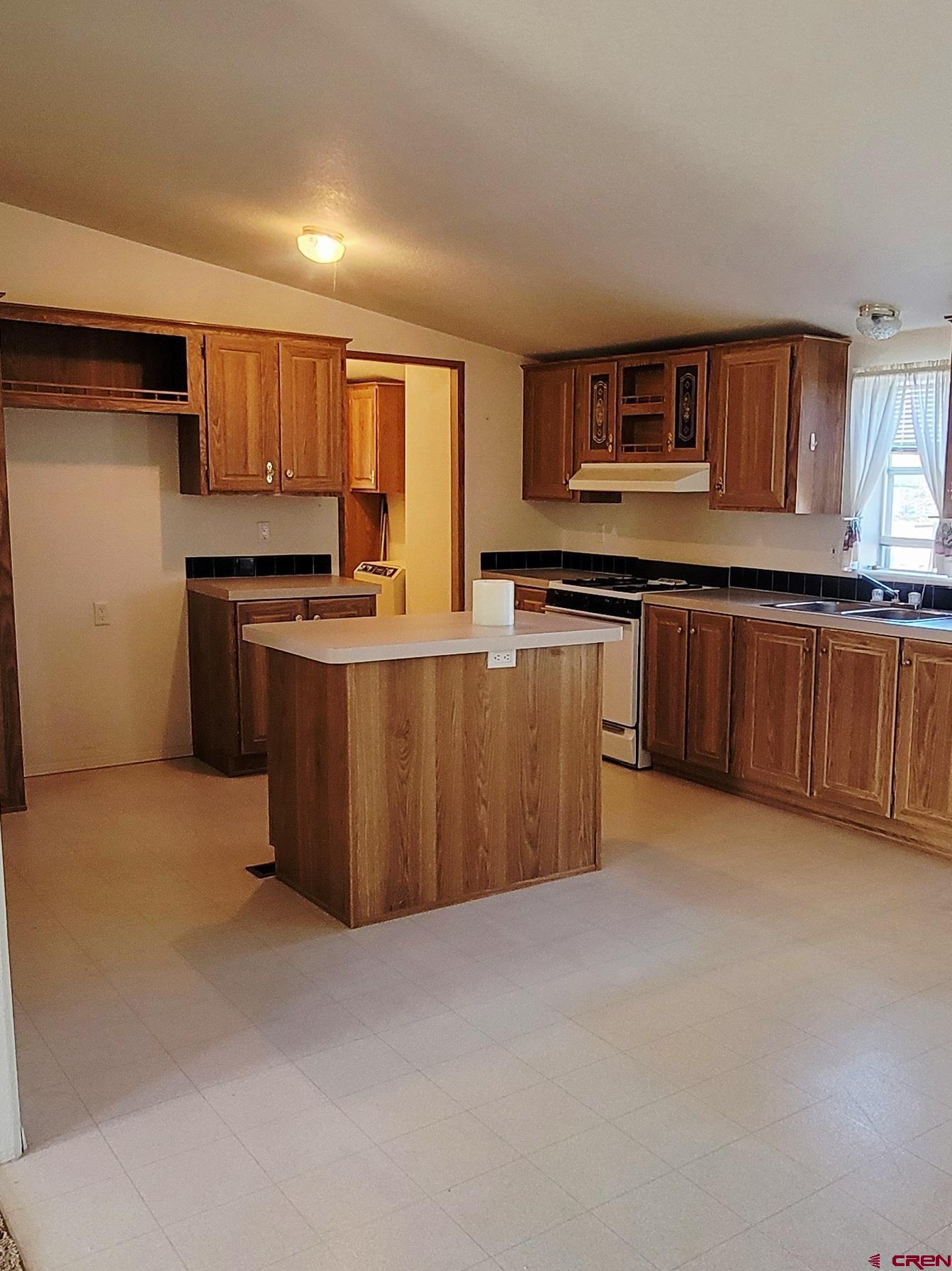 188 Vail Pass Road South Fork, CO 81154 - Photo 13 of 31 a kitchen with stainless steel appliances granite countertop a stove top oven a sink dishwasher and a refrigerator with wooden cabinets