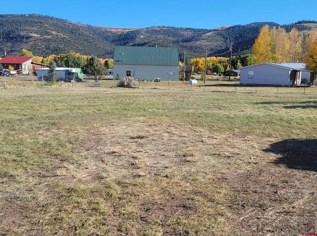 a view of a houses with yard and mountain view in back