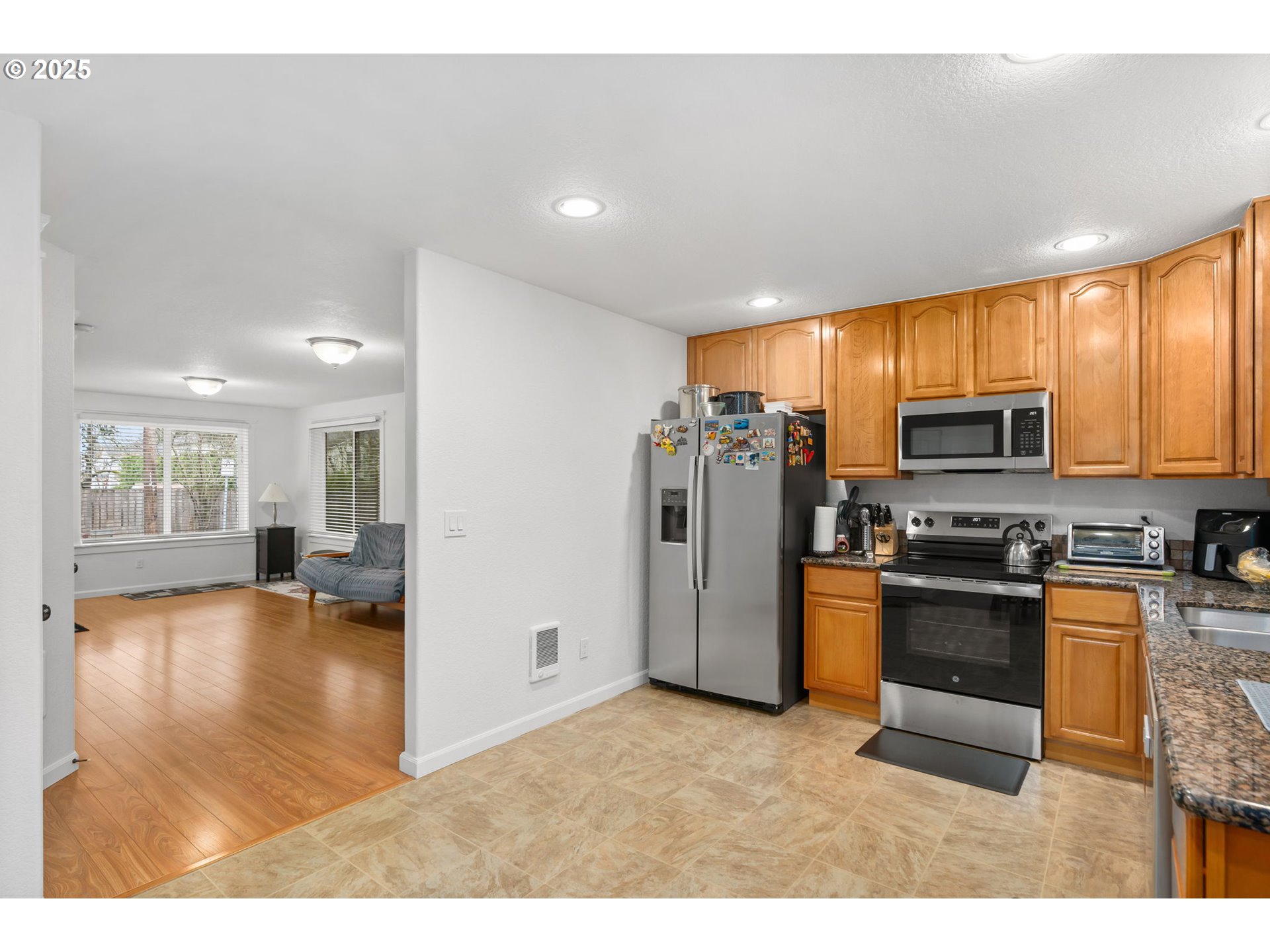 11938 Southeast Market Street Portland, OR 97216 - Photo 13 of 28 a kitchen with stainless steel appliances granite countertop a refrigerator stove top oven a sink and dishwasher