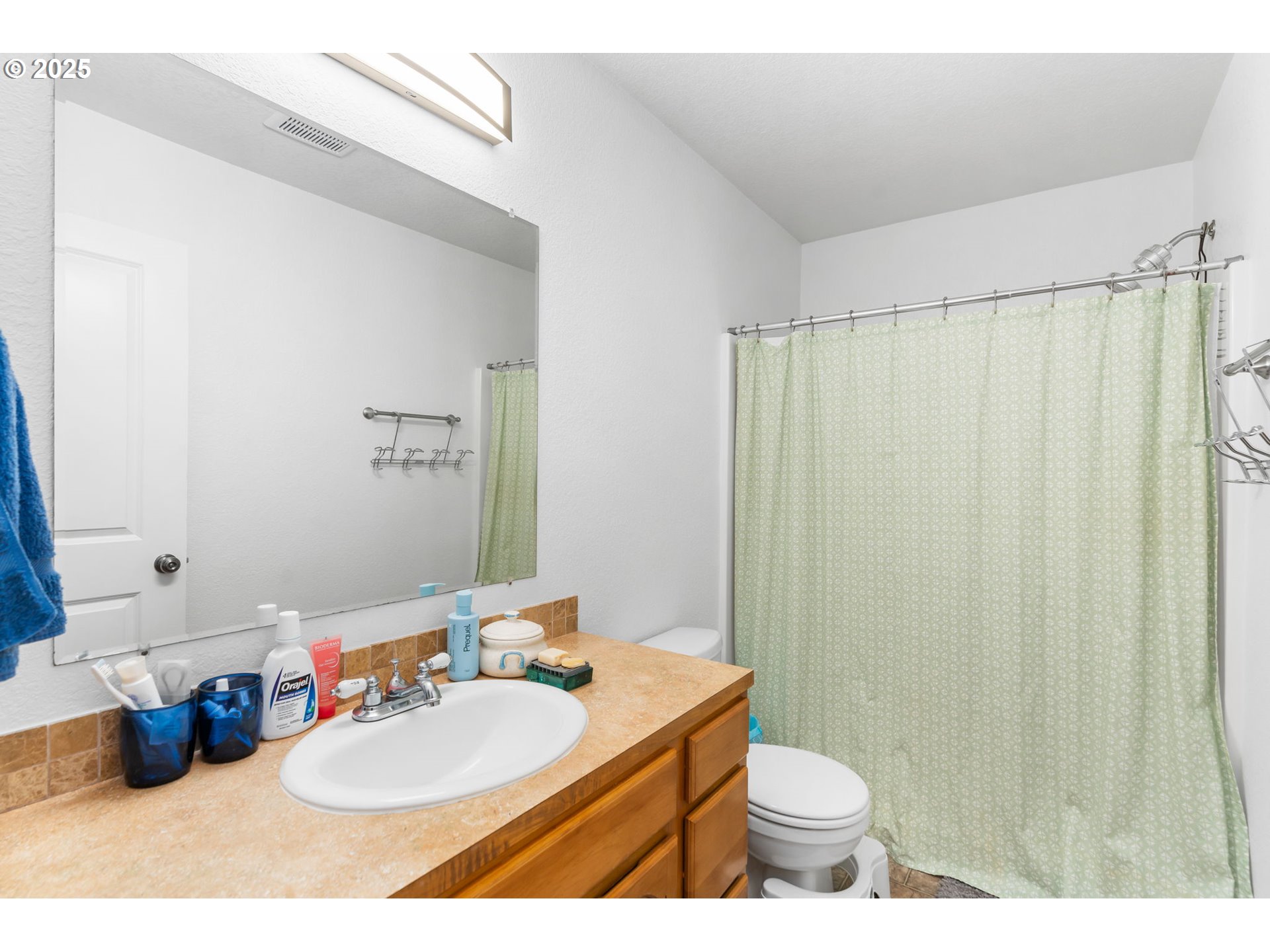 11938 Southeast Market Street Portland, OR 97216 - Photo 20 of 28 a bathroom with a sink a toilet and shower curtain