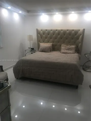 a spacious bedroom with a bed and a night stand