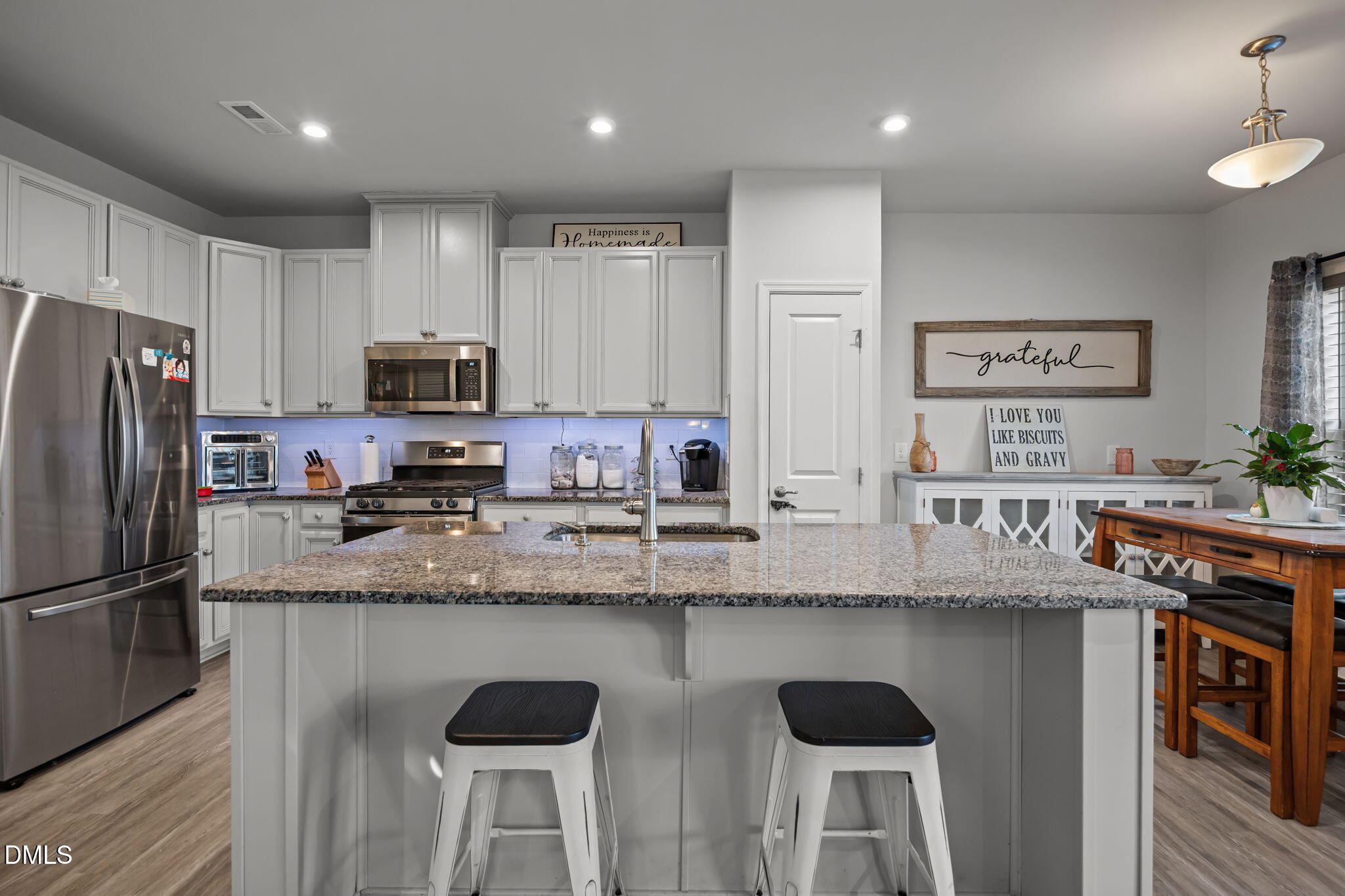1624 Ripley Woods Street Wake Forest, NC 27587 - Photo 12 of 41 a kitchen with stainless steel appliances granite countertop a sink a stove a refrigerator cabinets and chairs