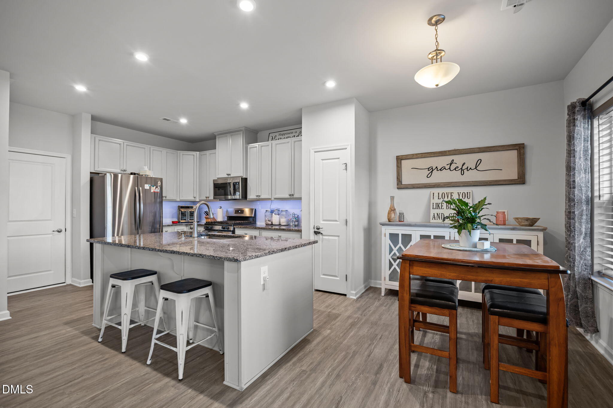 1624 Ripley Woods Street Wake Forest, NC 27587 - Photo 13 of 41 a kitchen with stainless steel appliances granite countertop a dining table chairs stove refrigerator and cabinets