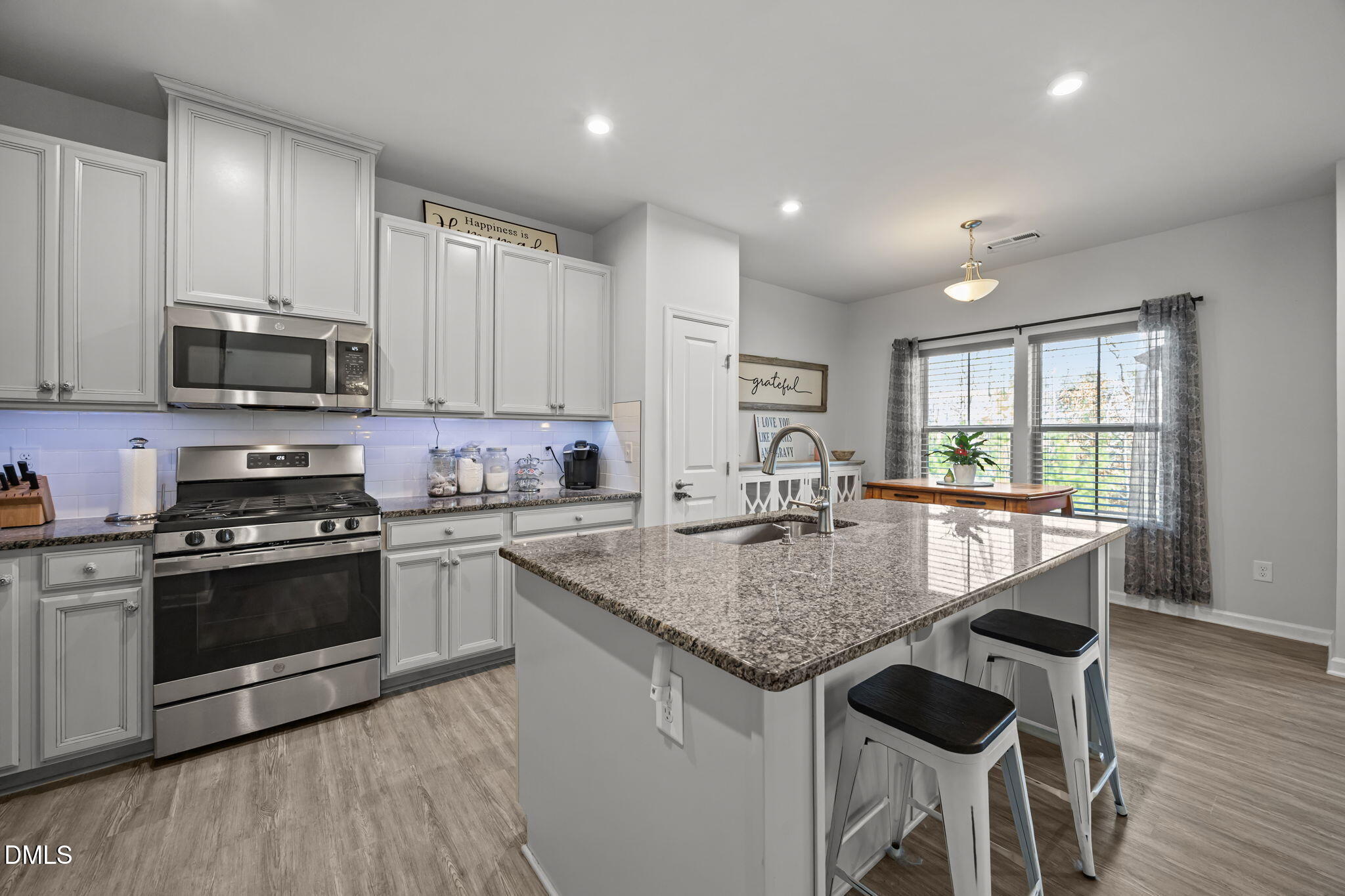 1624 Ripley Woods Street Wake Forest, NC 27587 - Photo 15 of 41 a kitchen with stainless steel appliances granite countertop a stove a sink a microwave a center island and a window