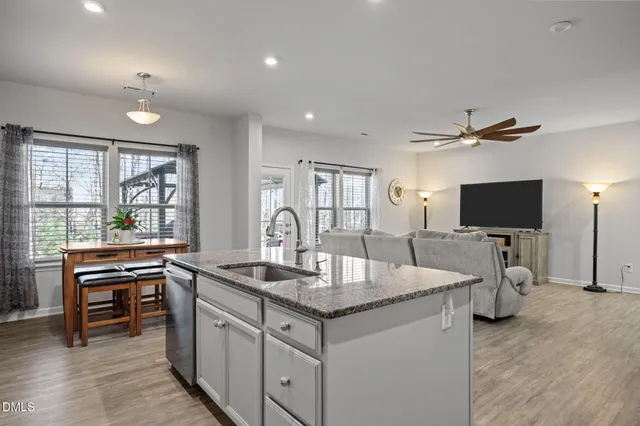a living room with granite countertop furniture and a flat screen tv
