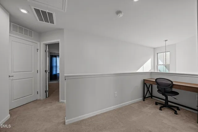 a view of a workspace with furniture and a window