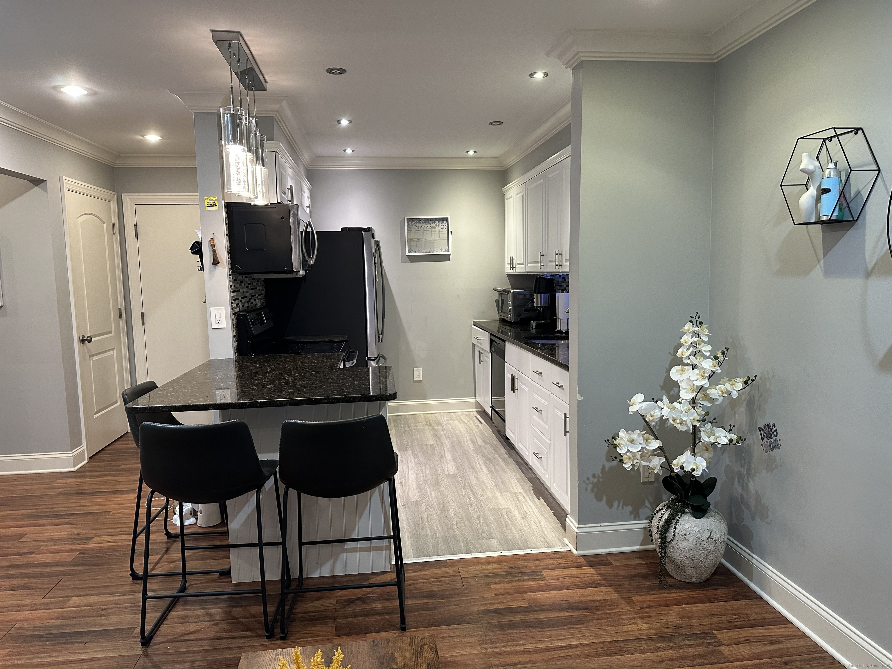 697 Cove Road, Unit 1E Stamford, CT 06902 - Photo 2 of 14 a kitchen with stainless steel appliances kitchen island granite countertop a dining table chairs and granite counter tops