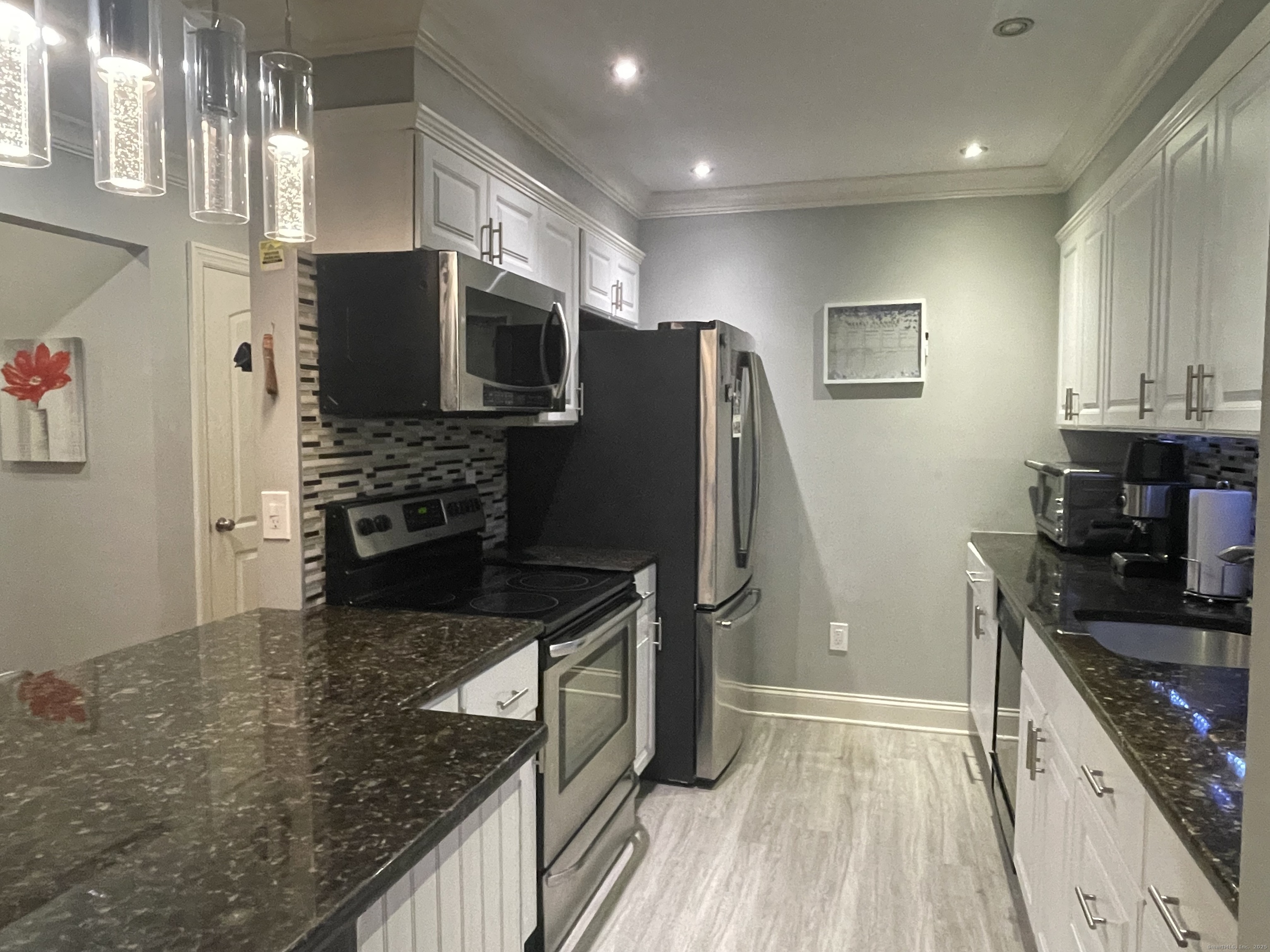 697 Cove Road, Unit 1E Stamford, CT 06902 - Photo 8 of 14 a kitchen with stainless steel appliances granite countertop a refrigerator stove and sink