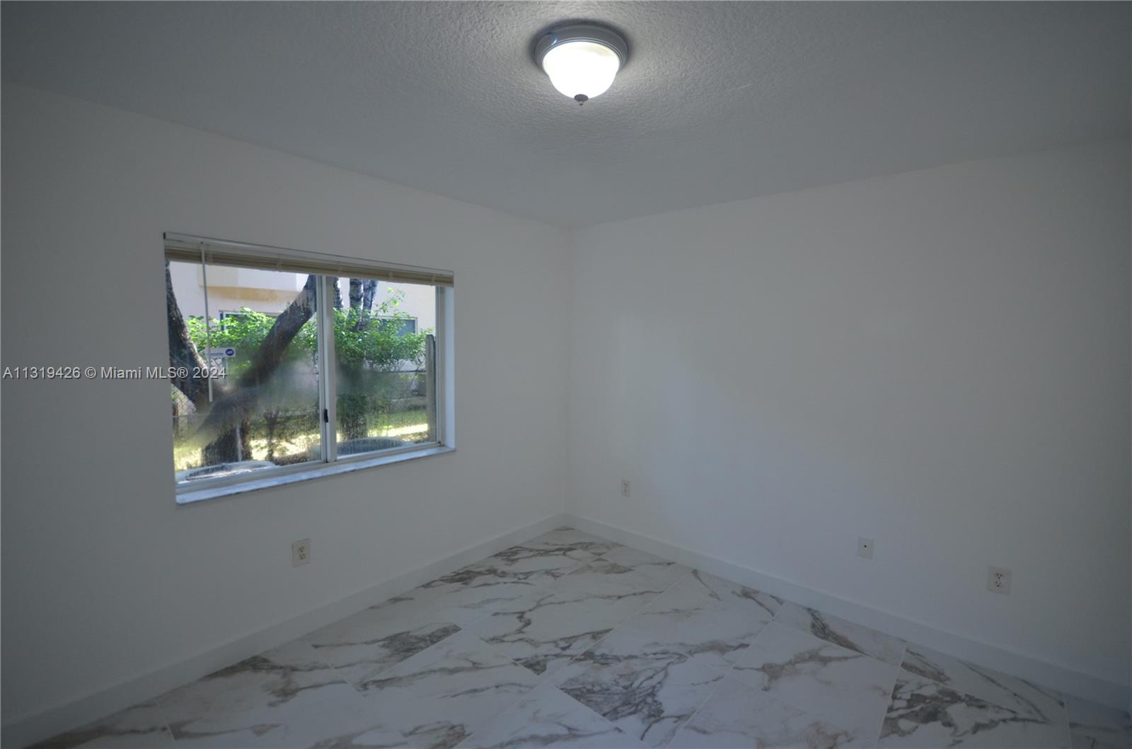 1241 Southeast 29th Street, Unit 102 Homestead, FL 33035 - Photo 17 of 23 an empty room with a window