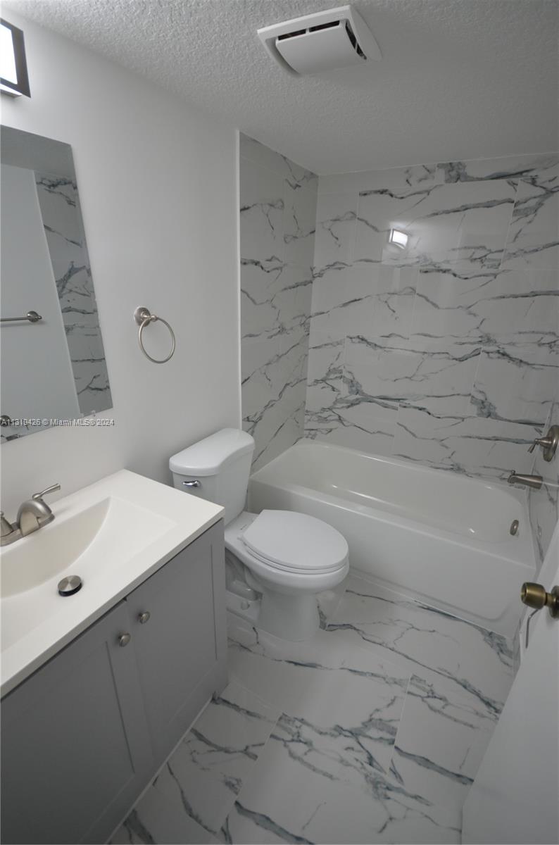 1241 Southeast 29th Street, Unit 102 Homestead, FL 33035 - Photo 20 of 23 a bathroom with a toilet sink and mirror