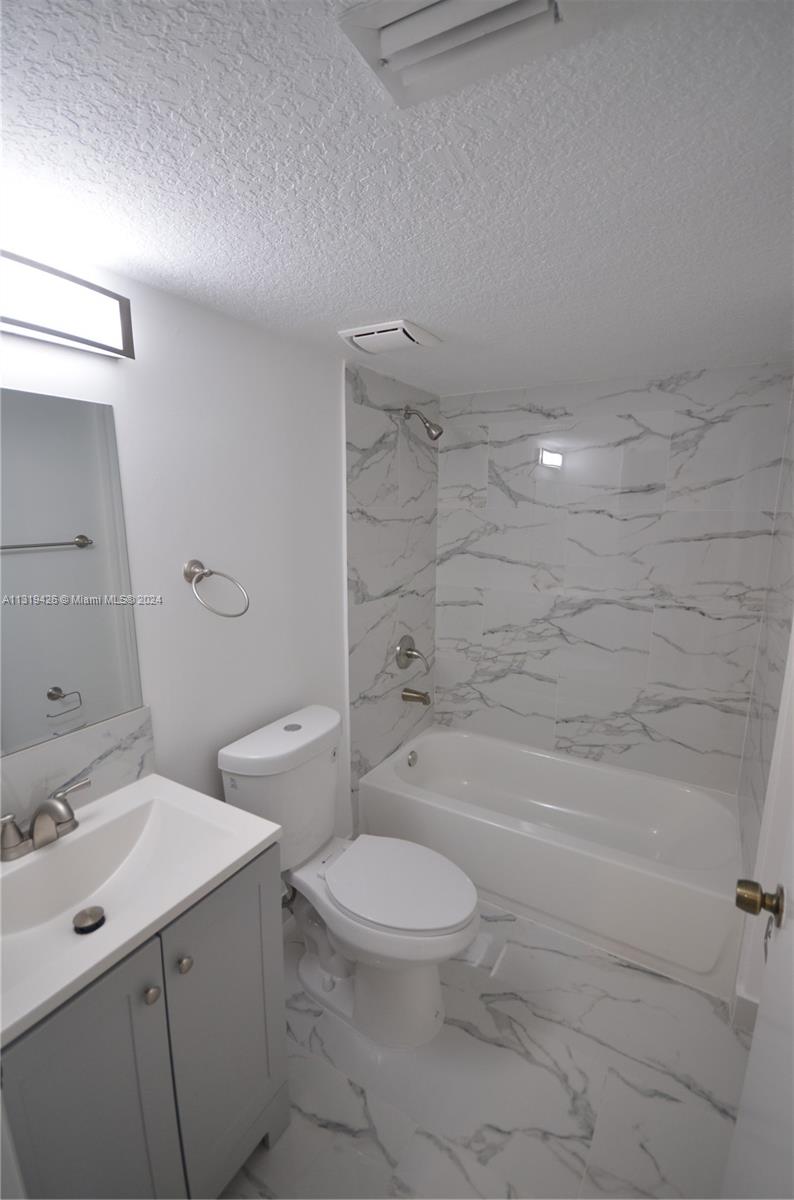 1241 Southeast 29th Street, Unit 102 Homestead, FL 33035 - Photo 10 of 23 a bathroom with a sink a toilet and shower