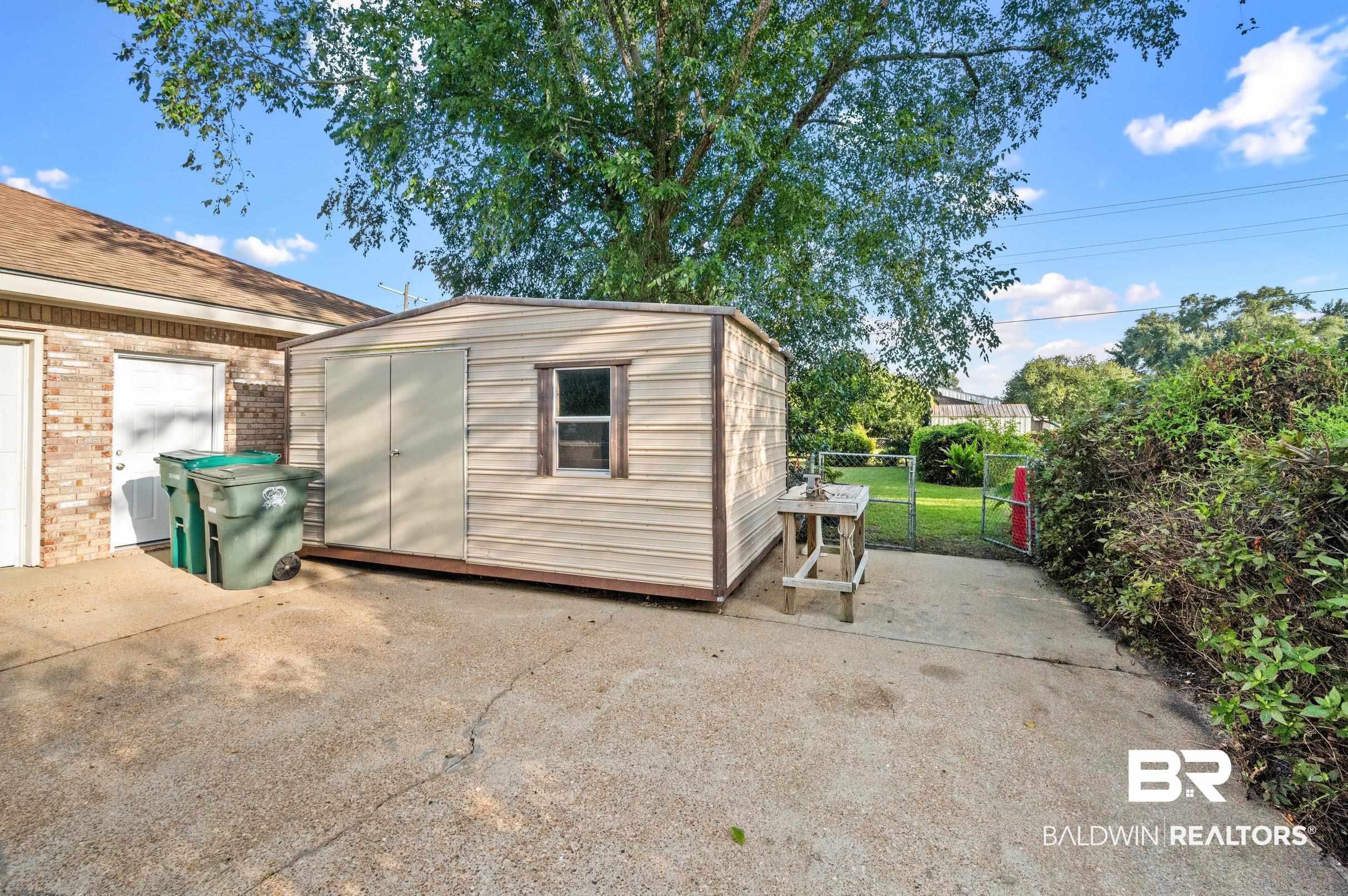 303 West Palm Avenue Foley, AL 36535 - Photo 27 of 32 View of patio / terrace with a shed