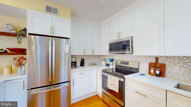 a kitchen with stainless steel appliances a refrigerator sink and microwave