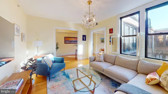 a living room with furniture a chandelier and a window