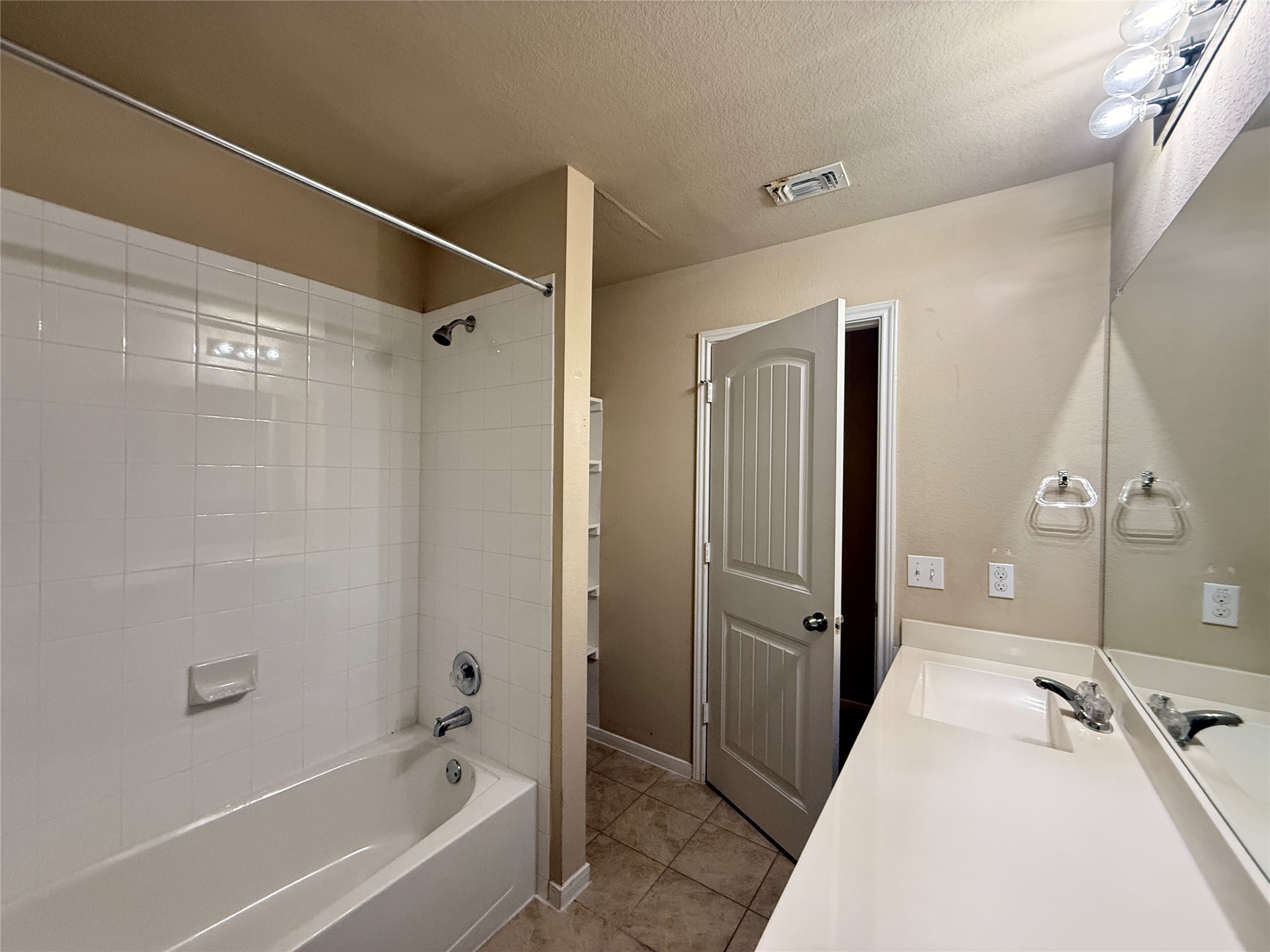 1602 Atlantica Street Cedar Park, TX 78613 - Photo 19 of 24 Full bathroom featuring tub / shower combination, a textured ceiling, vanity, and light tile patterned flooring