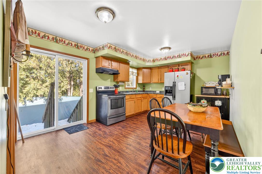 4859 Vera Cruz Road Emmaus, PA 18049 - Photo 7 of 23 a open kitchen with stainless steel appliances granite countertop a stove top oven a sink dishwasher and white cabinets with wooden floor