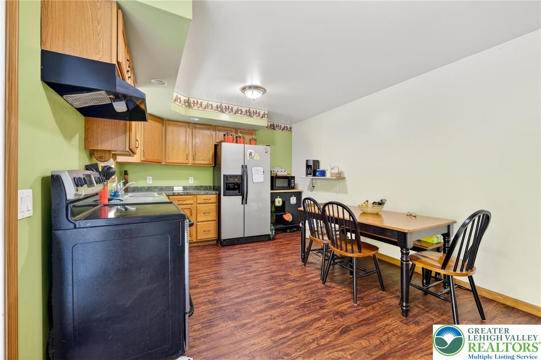 4859 Vera Cruz Road Emmaus, PA 18049 - Photo 8 of 23 a kitchen with stainless steel appliances a table chairs and refrigerator