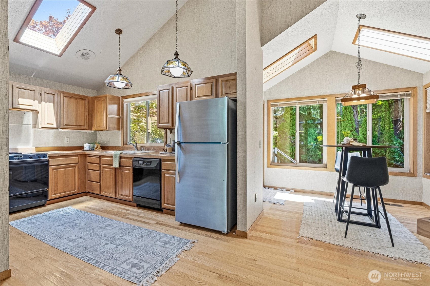 601 Clark Road Bellingham, WA 98225 - Photo 9 of 38 a kitchen with stainless steel appliances granite countertop a stove a refrigerator a oven with a dining table and chairs